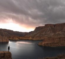 Figure standing at the edge of a lake